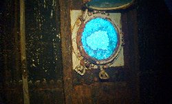 A broken porthole looks out to the sea beyond...