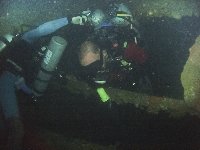 Mike being dragged through a hole inside the Olympia Maru on a deep swim thru by our guide TanTan...