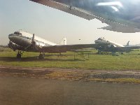 Two WW2 Dakotas on the grass next to the runway at Manila airport...